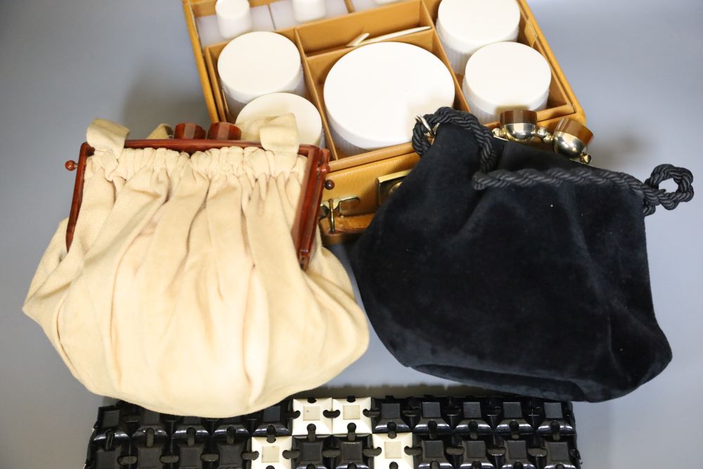 A 1960s plastic black and cream clutch bag, a black velvet bag and cream bag with Bakelite frame and a leather travel case